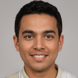 Joyful latino young-adult male with short  black hair and brown eyes