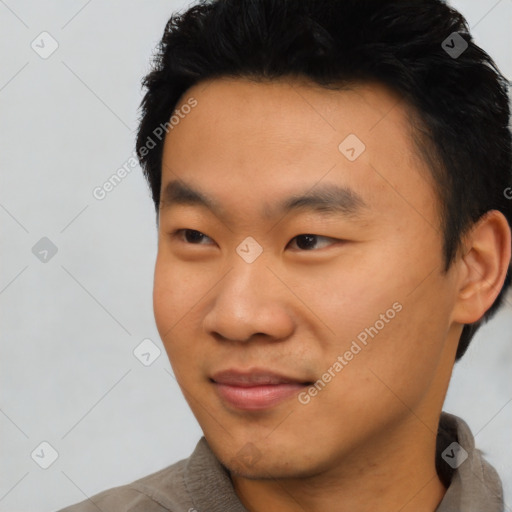 Joyful asian young-adult male with short  black hair and brown eyes