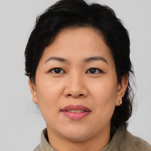 Joyful asian adult female with medium  brown hair and brown eyes