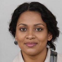 Joyful black adult female with long  brown hair and brown eyes