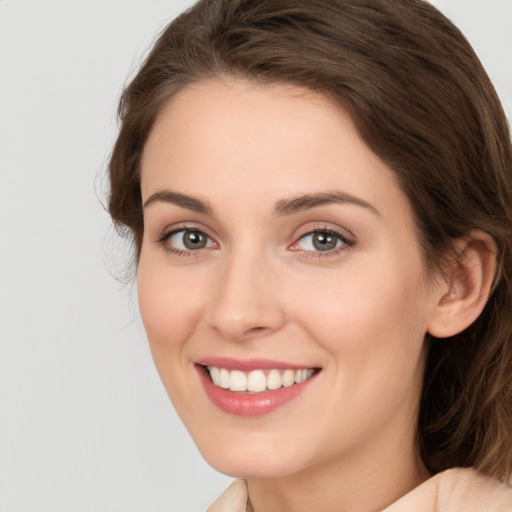 Joyful white young-adult female with medium  brown hair and green eyes