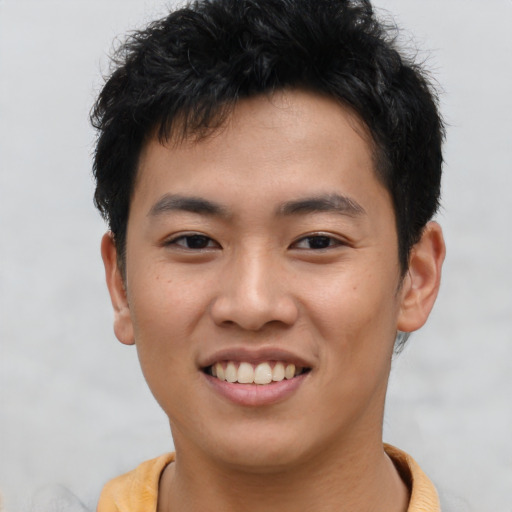 Joyful asian young-adult male with short  brown hair and brown eyes