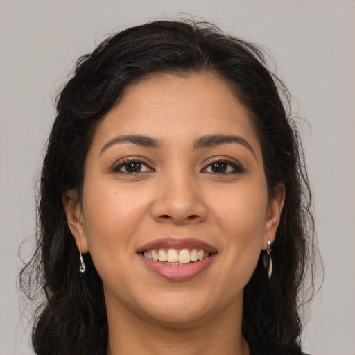 Joyful latino young-adult female with long  brown hair and brown eyes