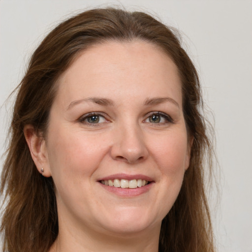 Joyful white adult female with long  brown hair and grey eyes