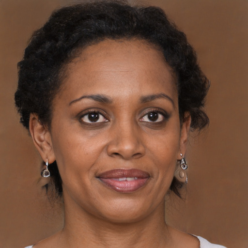 Joyful black adult female with medium  brown hair and brown eyes