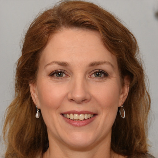 Joyful white adult female with long  brown hair and green eyes