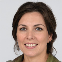 Joyful white adult female with medium  brown hair and green eyes