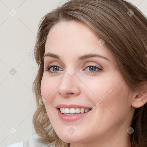 Joyful white young-adult female with long  brown hair and blue eyes