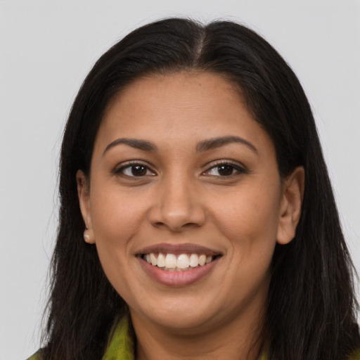 Joyful latino young-adult female with long  brown hair and brown eyes