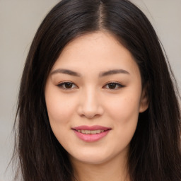 Joyful asian young-adult female with long  brown hair and brown eyes