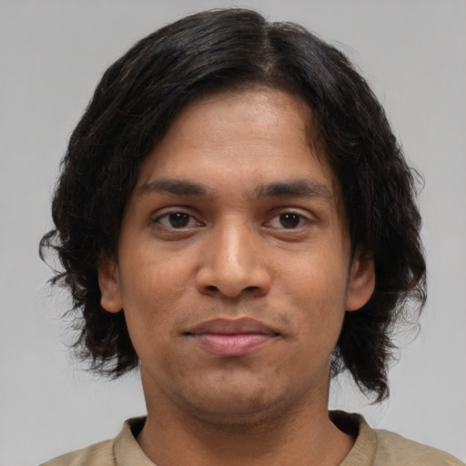 Joyful black young-adult male with medium  brown hair and brown eyes