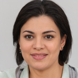 Joyful latino young-adult female with medium  brown hair and brown eyes