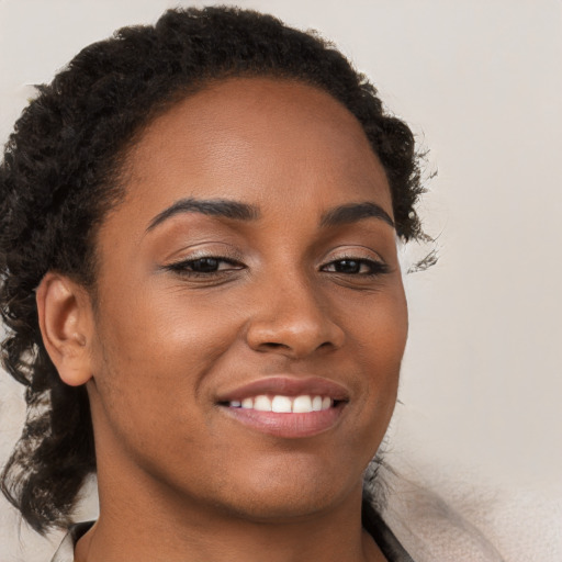 Joyful black young-adult female with medium  brown hair and brown eyes