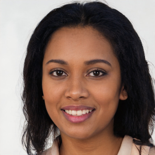Joyful black young-adult female with long  brown hair and brown eyes