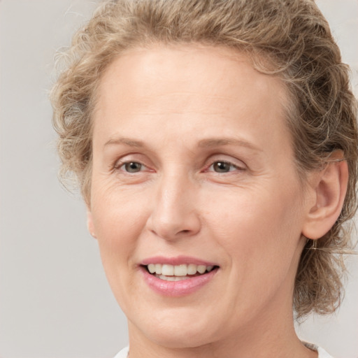 Joyful white adult female with medium  brown hair and grey eyes