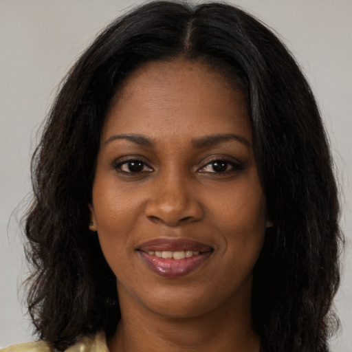 Joyful black young-adult female with long  brown hair and brown eyes