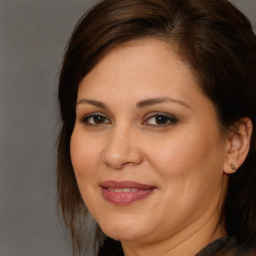 Joyful white adult female with long  brown hair and brown eyes
