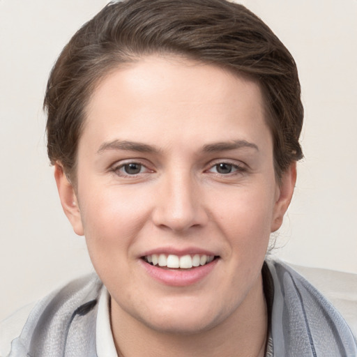 Joyful white young-adult female with short  brown hair and grey eyes