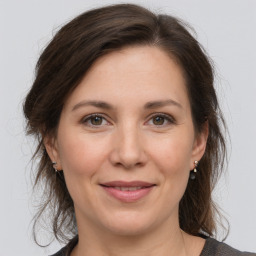 Joyful white young-adult female with medium  brown hair and grey eyes