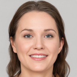 Joyful white young-adult female with medium  brown hair and grey eyes