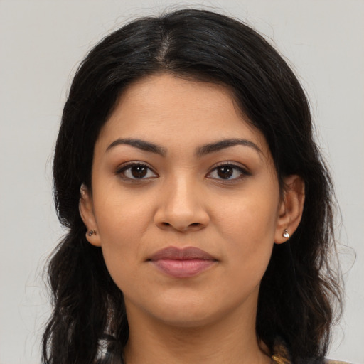 Joyful latino young-adult female with long  brown hair and brown eyes
