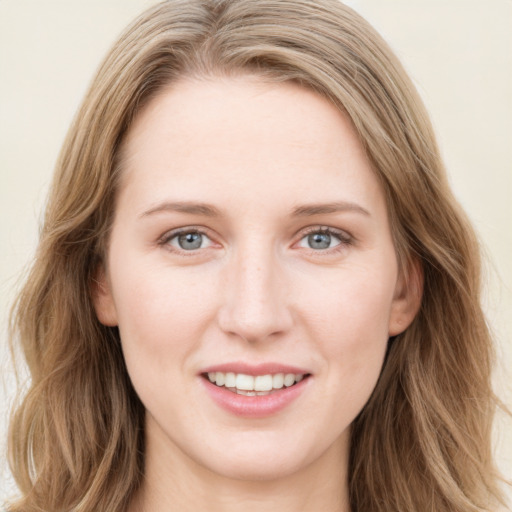 Joyful white young-adult female with long  brown hair and blue eyes