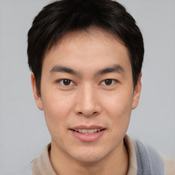 Joyful asian young-adult male with short  brown hair and brown eyes