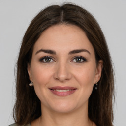 Joyful white young-adult female with long  brown hair and brown eyes