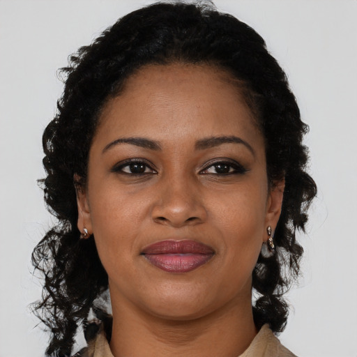 Joyful black young-adult female with long  black hair and brown eyes