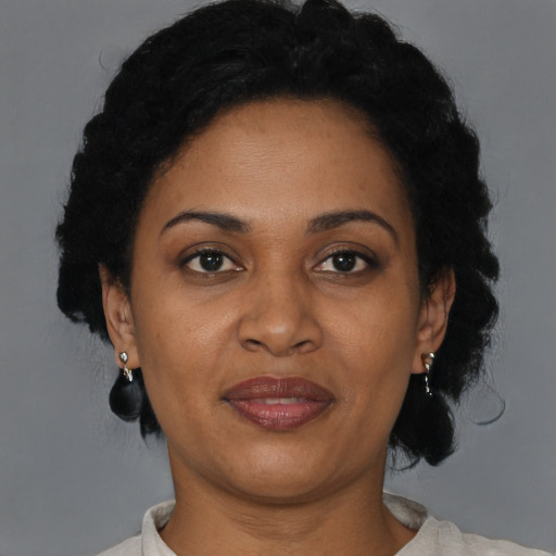 Joyful black adult female with short  black hair and brown eyes