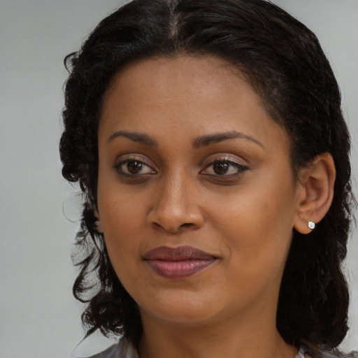 Joyful black young-adult female with medium  brown hair and brown eyes