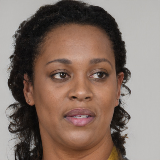 Joyful black adult female with long  brown hair and brown eyes
