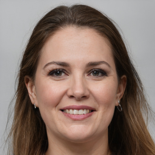 Joyful white adult female with long  brown hair and grey eyes