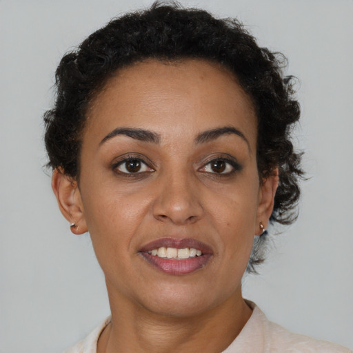 Joyful black young-adult female with short  brown hair and brown eyes