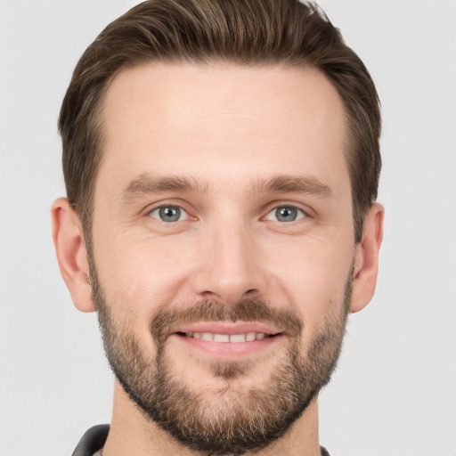 Joyful white young-adult male with short  brown hair and grey eyes