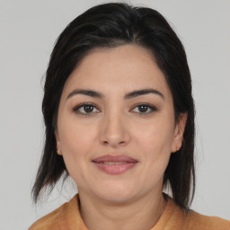 Joyful latino young-adult female with medium  brown hair and brown eyes