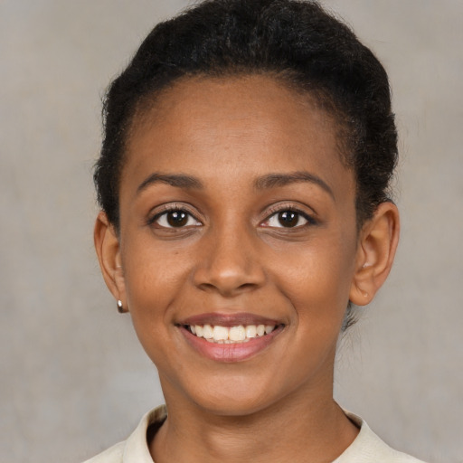 Joyful black young-adult female with short  brown hair and brown eyes