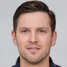 Joyful white young-adult male with short  brown hair and grey eyes