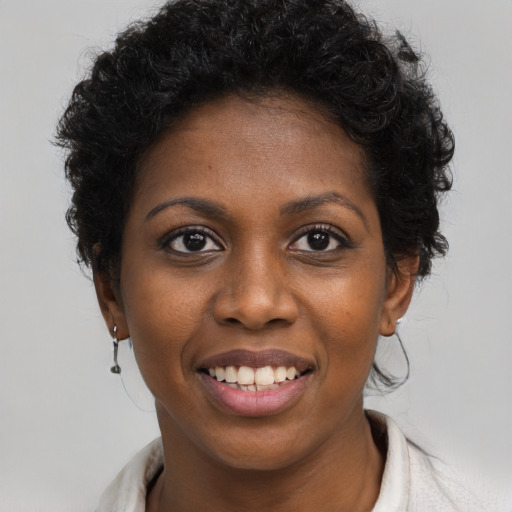 Joyful black young-adult female with short  black hair and brown eyes