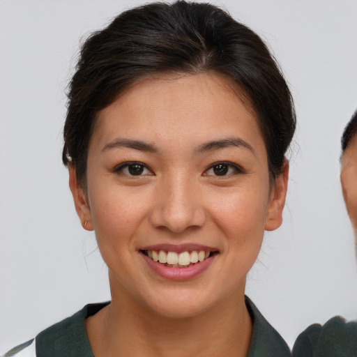 Joyful asian young-adult female with short  brown hair and brown eyes
