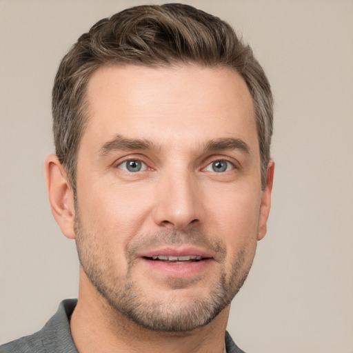 Joyful white young-adult male with short  brown hair and grey eyes