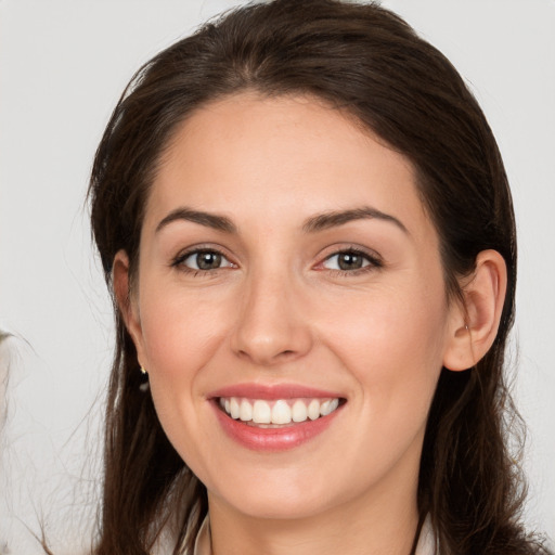 Joyful white young-adult female with long  brown hair and brown eyes