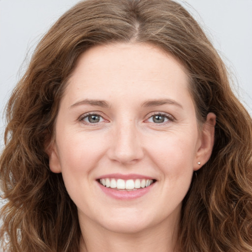 Joyful white young-adult female with long  brown hair and green eyes