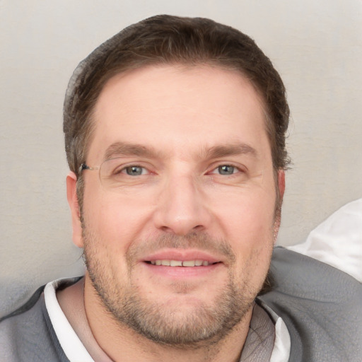 Joyful white adult male with short  brown hair and grey eyes