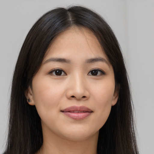 Joyful asian young-adult female with long  brown hair and brown eyes