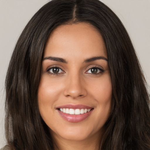 Joyful white young-adult female with long  brown hair and brown eyes