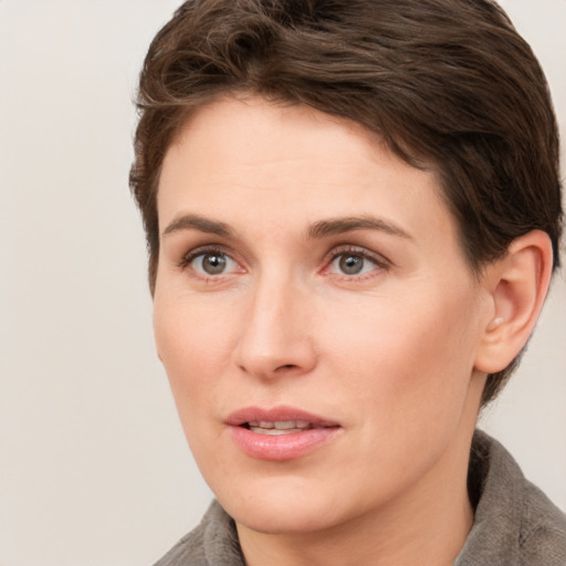 Joyful white young-adult female with short  brown hair and grey eyes