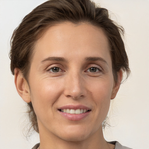 Joyful white adult female with medium  brown hair and brown eyes