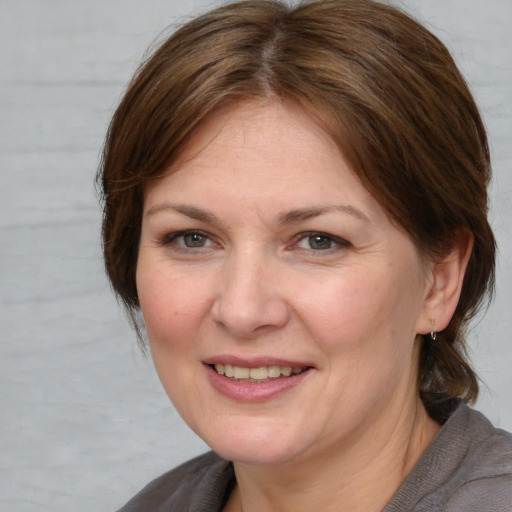 Joyful white adult female with medium  brown hair and brown eyes