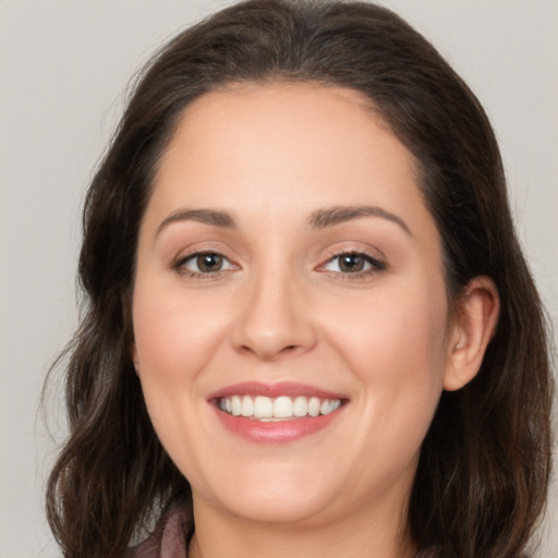 Joyful white young-adult female with long  brown hair and brown eyes